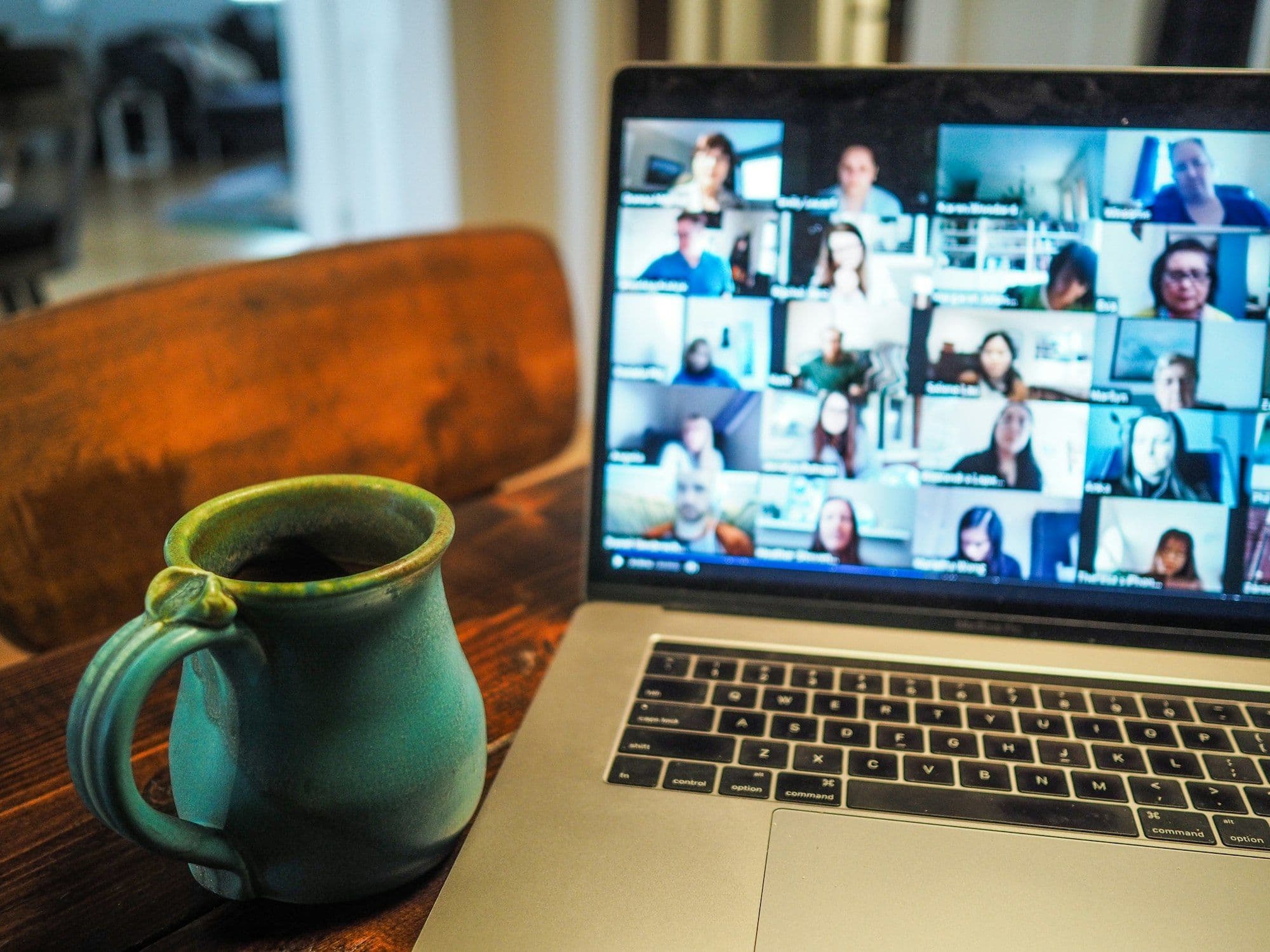 A laptop showing a grid of video call participants during an online event