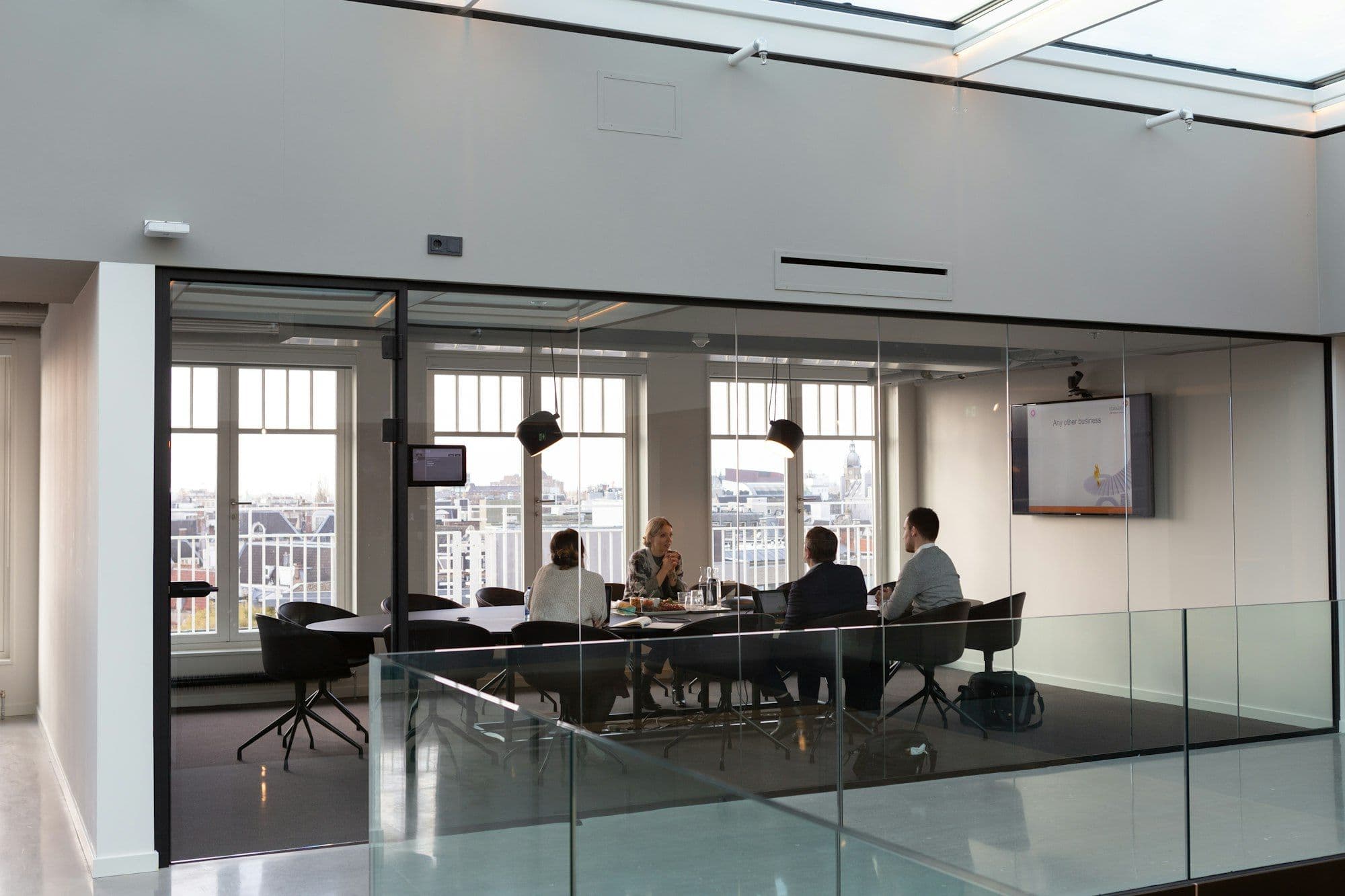 Colleagues around a table in a meeting room, mid-discussion